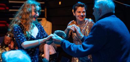 A group of people joining hands and laughing